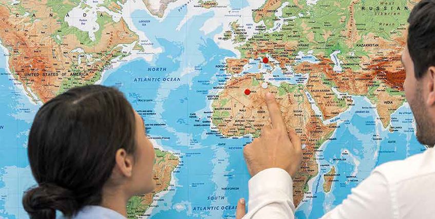 Woman and man looking at a map with pins stuck into it