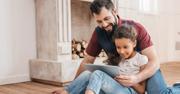 Father and daughter looking at a digital tablet