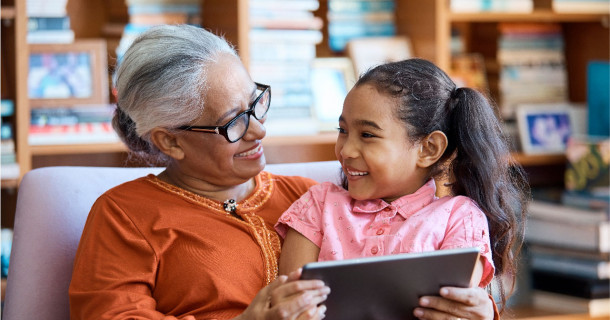 Grandmother and child looking at digital tablet in a lounge room